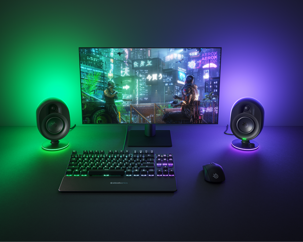  A desktop setup featuring the Arena 7 speakers lit up in ambient RGB lighting. 